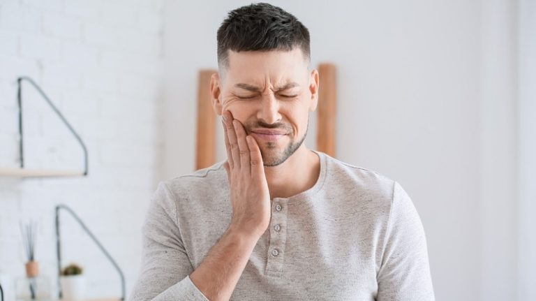 Can Gum Disease Heal Naturally? Man holding cheek with hand