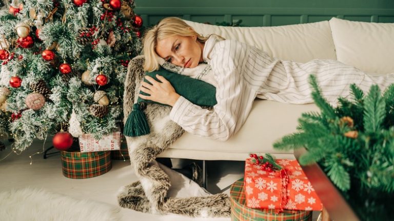 A Clinical Psychologist's Advice for Coping with Holiday Loneliness woman sits looking sad and lonely