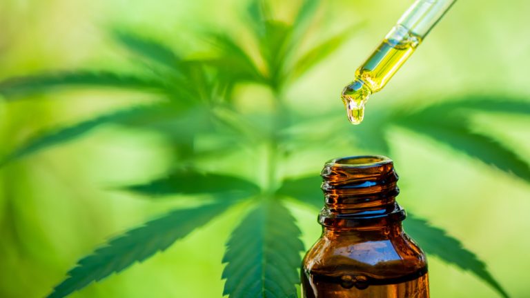 How CBD Effectively Treats Anxiety: What You Need to Know CBD oil dropper held over bottle