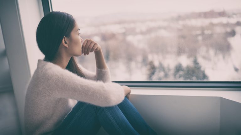 How Loneliness Can Physically Alter Your Brain Young woman looking out window