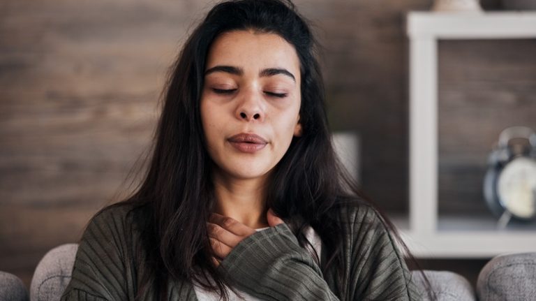 Life Hack: How to Clear Anxiety with Pressure Points woman holding her chest to calm herself