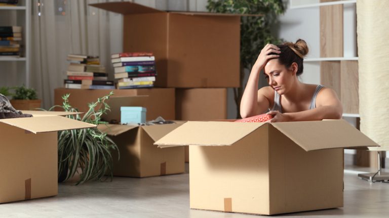 Reasons Why You Might Experience Depression After Moving a woman sits in moving box
